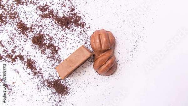 Fototapeta Close-up of a few ounces of chocolate on cocoa powder. On a white background