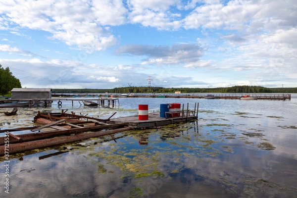 Fototapeta wood, the old pier with the barrels to fuel the engines of boats on the reservoir