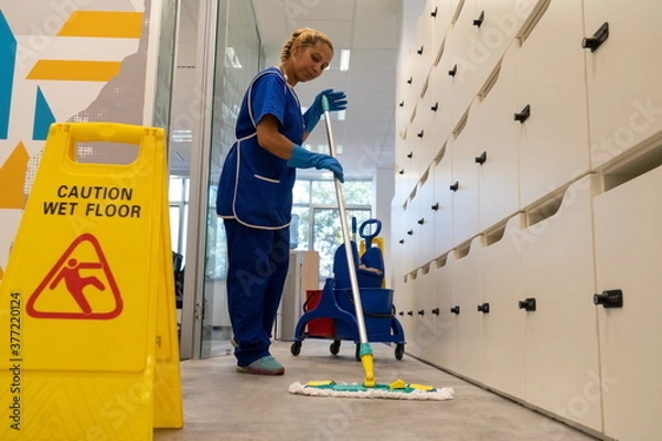 Fototapeta 
A cleaning leady cleans the floor in an office with mop