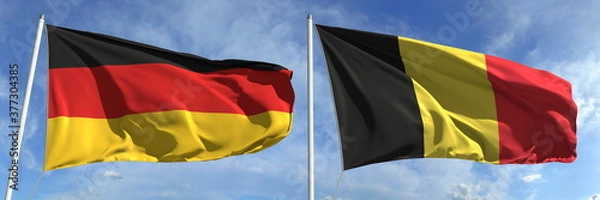 Fototapeta Waving flags of Germany and Belgium on flagpoles, 3d rendering