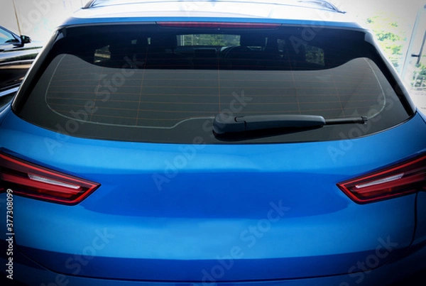 Fototapeta Image of Rear view of blue car with rear wiper, defogger wires and rear lights on background  