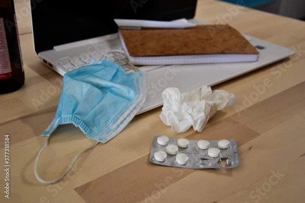 Fototapeta Being sick working from home. Protection mask, pills and napkin to prevent the spread of virus. Covid-19
