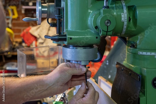 Fototapeta Using an Allen key wrench to undo the fixing screws in the head mechanism of a drill chuck on a lathe