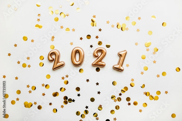Fototapeta Gold holiday numbers 2021 on a white background with gold confetti. Christmas or New Year conceptual background.