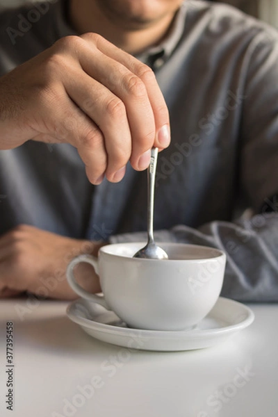 Fototapeta 
The guy is drinking tea while sitting in a cafe
