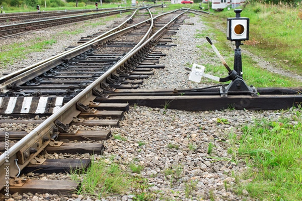 Fototapeta Arrow for switching the railway with rail track elements. Old railway tracks with wooden sleepers.