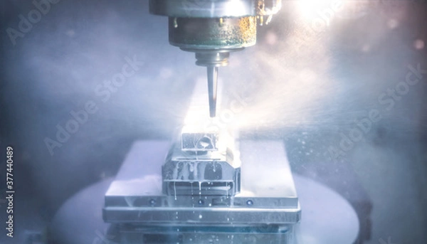 Fototapeta Moderne Fräsmaschine bearbeitet einen Metallblock aus Edelstahl - Industrielle Fertigung in der Fabrik