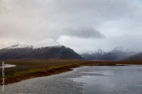 Fototapeta clouds over the snowy mountains in iceland