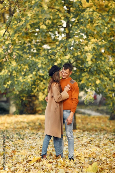 Fototapeta Cute couple in a park. Family in autumn clothes. Man in a brown sweater.