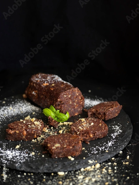 Obraz Sweet salami against black background