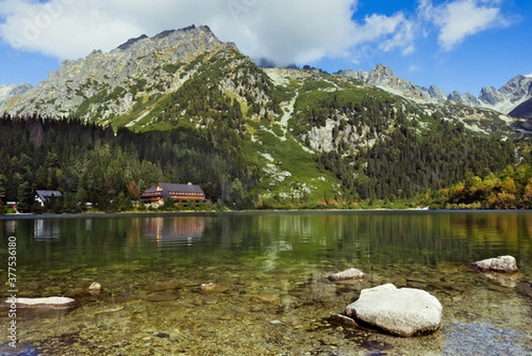 Fototapeta Mountain lake with a couple of small rocks in the foreground 