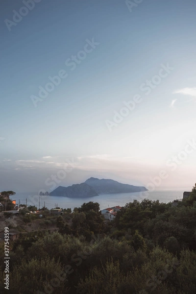 Fototapeta sunset over capri, italy, From the top of a mountain you can see the historic island in all its glory