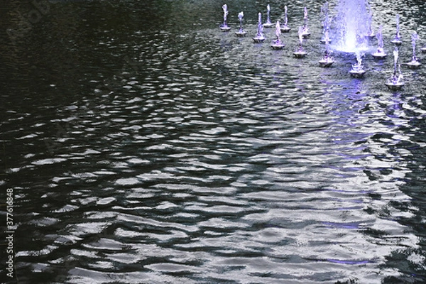 Obraz 少しだけ水が出ている噴水と波紋の美しい水面