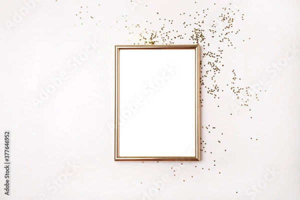 Fototapeta Empty gold frame for text and gold stars Christmas decor. Flat lay style. Blank for a holiday wish