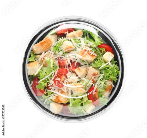 Fototapeta Delicious fresh salad in plastic container with lid on white background, top view