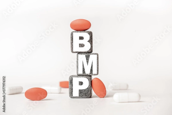 Fototapeta a group of white and red pills and cubes with the word BMP: Basic metabolic panel on them, white background. Concept carehealth, treatment, therapy.