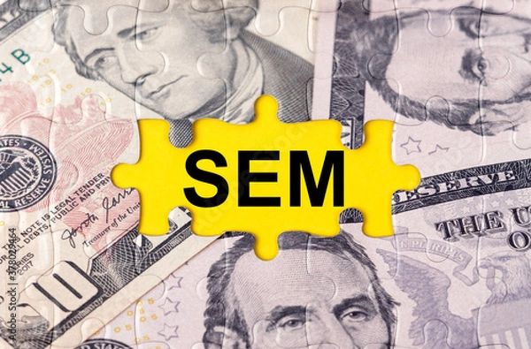 Fototapeta Puzzle with the image of dollars in the center of the inscription -SEM