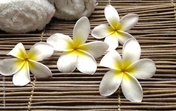 Fototapeta Set of four frangipani and towel on stick straw mat