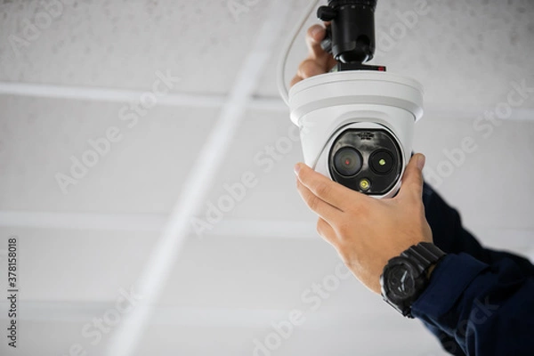 Fototapeta Technician installing IP wireless CCTV camera by screwed for home security system and installed
