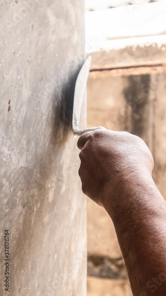 Fototapeta Tiler's hand.bricklayer plaster a wall inside a building