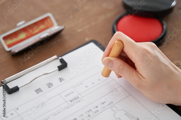 Fototapeta 書類に個人の印鑑を押す日本人女性の手元