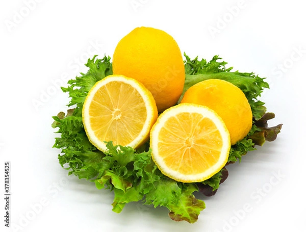 Fototapeta Lemon and half sliced lemon on salad leaves