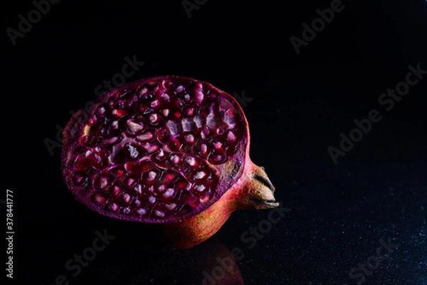Obraz close up photo of cut pomegranate in dark background
