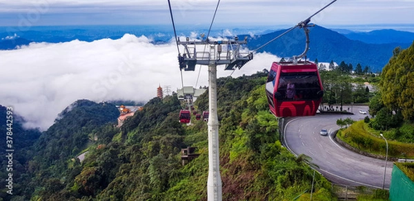 Obraz cable car at genting highlands, malaysia in a foggy weather with green grass visible from inside cable car