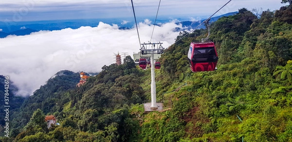 Obraz cable car at genting highlands, malaysia in a foggy weather with green grass visible from inside cable car