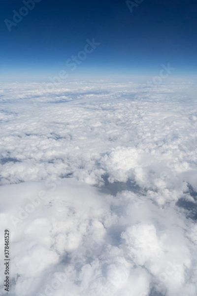 Obraz Vertical landscape over the clouds from airplane