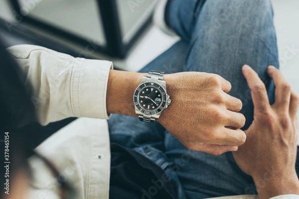 Fototapeta fashionable wearing stylish looking at luxury watch on hand check the time at workplace.concept for managing time organization working,punctuality,appointment
