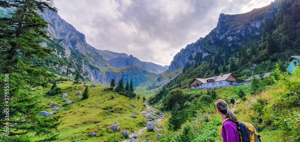 Obraz Wanderin vor Berghütte in einem Tal der rumänischen Karpaten