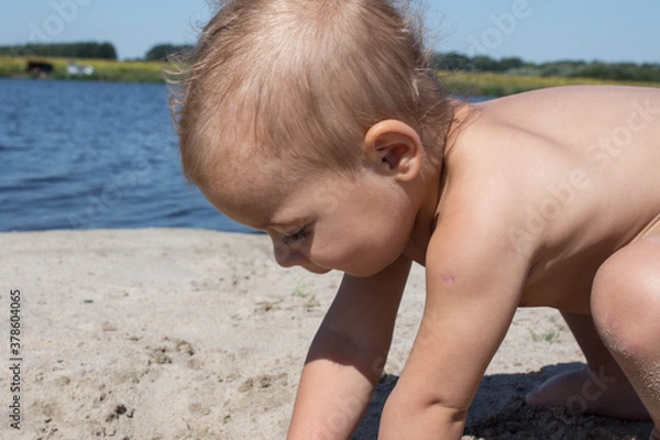 Fototapeta a beautiful little child playing in the sand