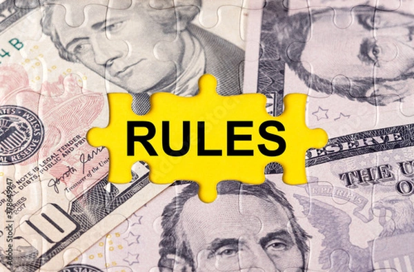Fototapeta Puzzle with the image of dollars in the center of the inscription -RULES