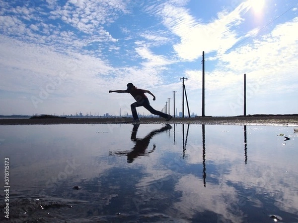 Obraz 電柱のある海で見えない敵に向かってパンチしている人