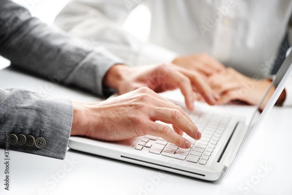 Fototapeta businessman typing on a white computer keyboard, woman on backgr