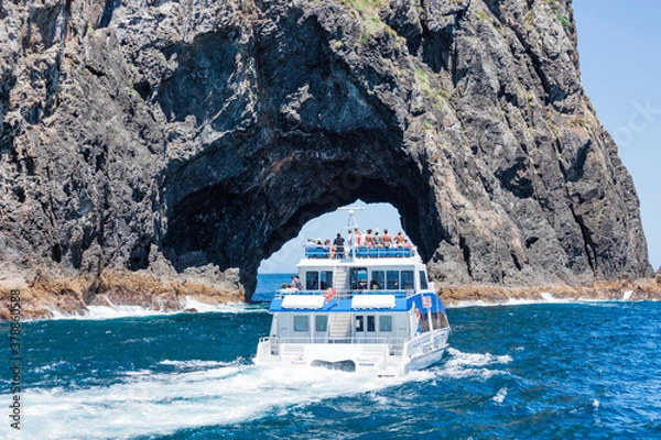 Fototapeta Tour boat entering The Hole in the Rock in Bay of Islands, New Zealand