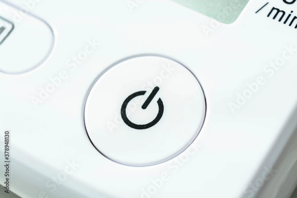 Fototapeta closeup of white power button on device for measuring blood pressure
