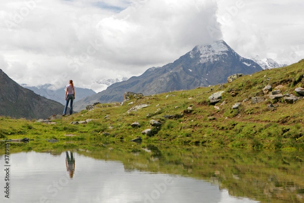 Fototapeta Young woman hiker having a rest after long walk in mountains