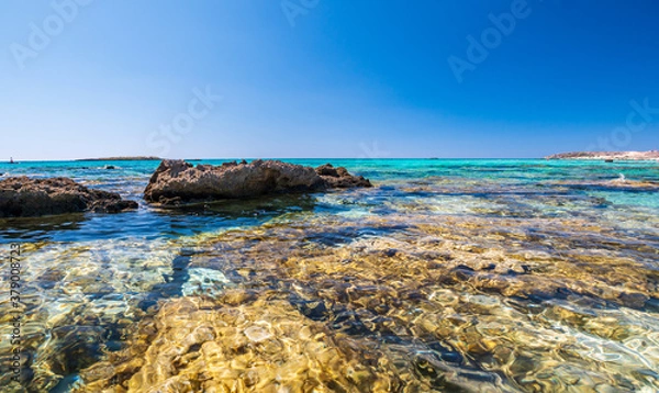 Fototapeta Elafonisi Crete Beach view to crystal clear water with nature rocks at the background