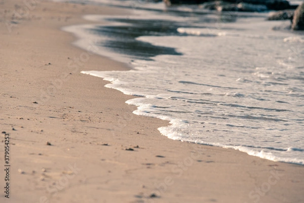 Obraz Small waves rolling onto a sandy beach
