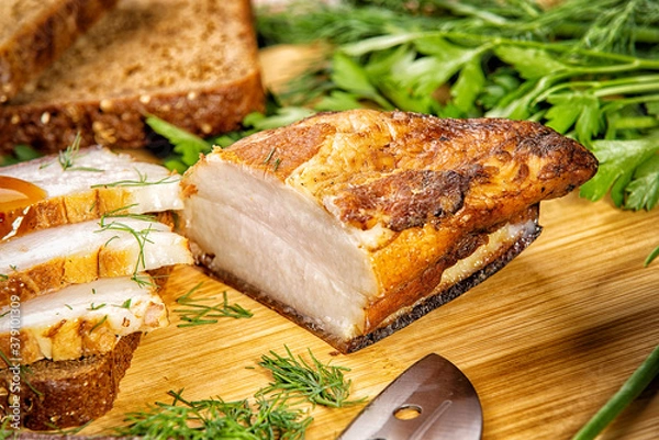 Fototapeta smoked meat lies on the table with herbs and sauce