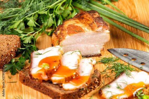 Fototapeta smoked meat lies on the table with herbs and sauce