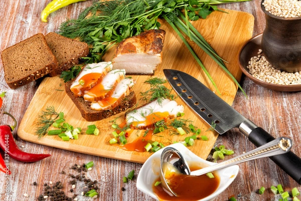 Fototapeta smoked meat lies on the table with herbs and sauce