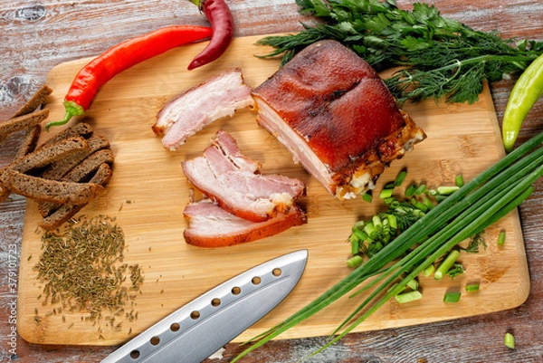 Fototapeta smoked meat lies on the table with herbs and sauce