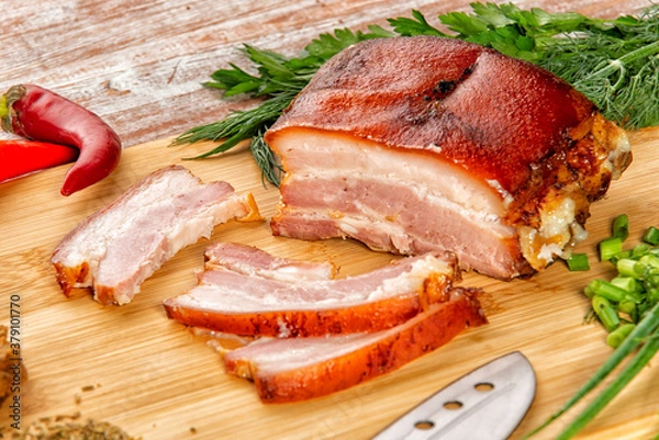 Fototapeta smoked meat lies on the table with herbs and sauce