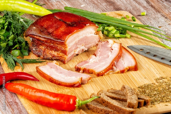 Fototapeta smoked meat lies on the table with herbs and sauce