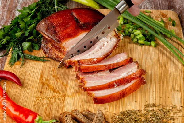 Fototapeta smoked meat lies on the table with herbs and sauce