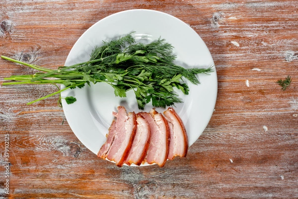 Fototapeta smoked meat lies on the table with herbs and sauce