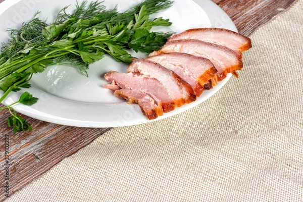 Fototapeta smoked meat lies on the table with herbs and sauce